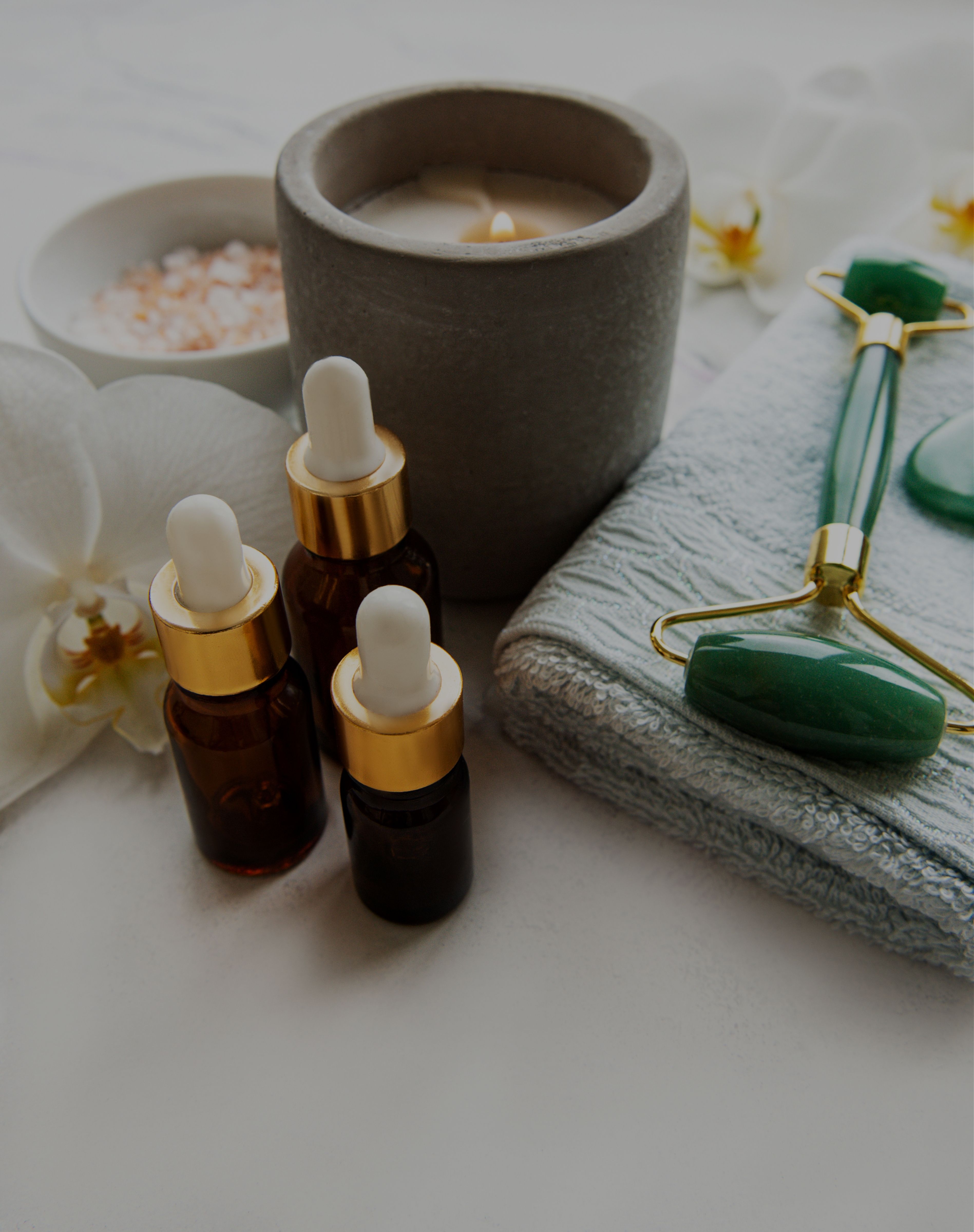 Spa skincare products including oil, towel, and citrus on a white background
